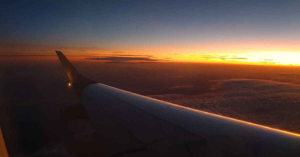 Aircraft wing above the clouds at sunset
